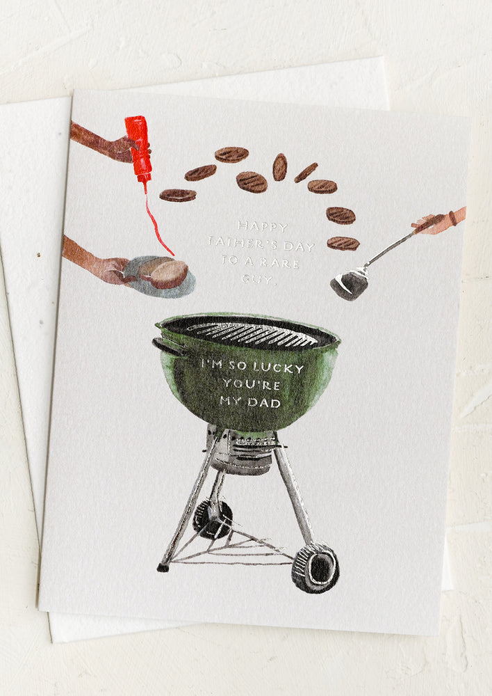A card with image of burgers and grill, text reads "Happy Father's Day To A Rare Guy".