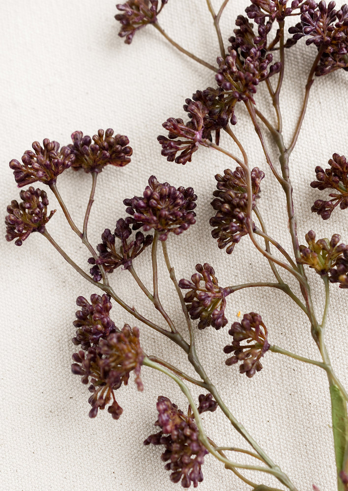 3: A faux sedum branch with dainty buds in aubergine.