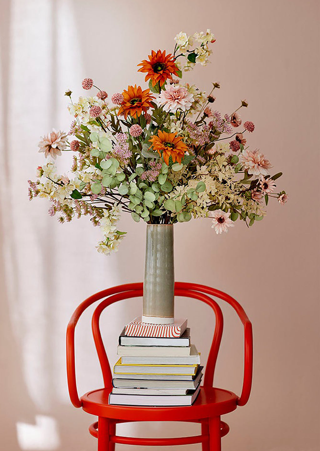 3: A faux flower arrangement with pink flowers and orange sunflowers.