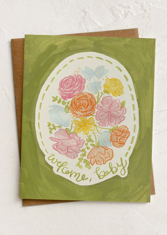 Greeting card with floral design and 'welcome, baby' text on a green background
