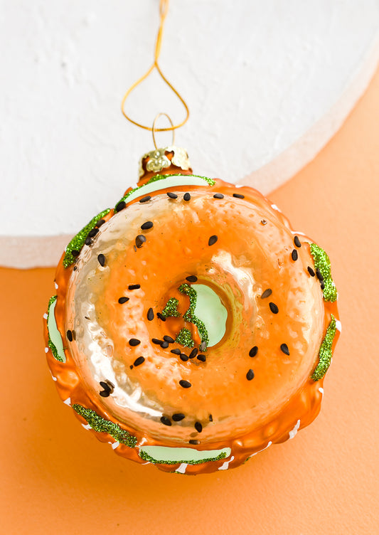 A glass ornament that looks like a bagel with lox.