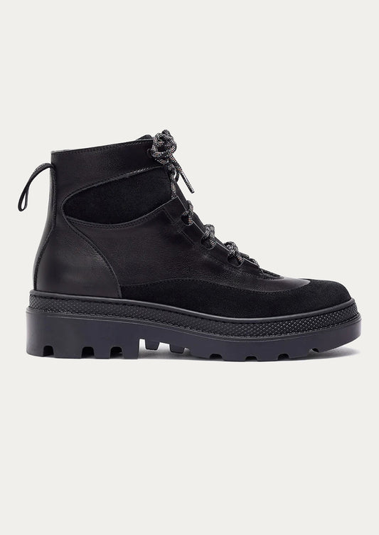 Black leather boot on a light gray background