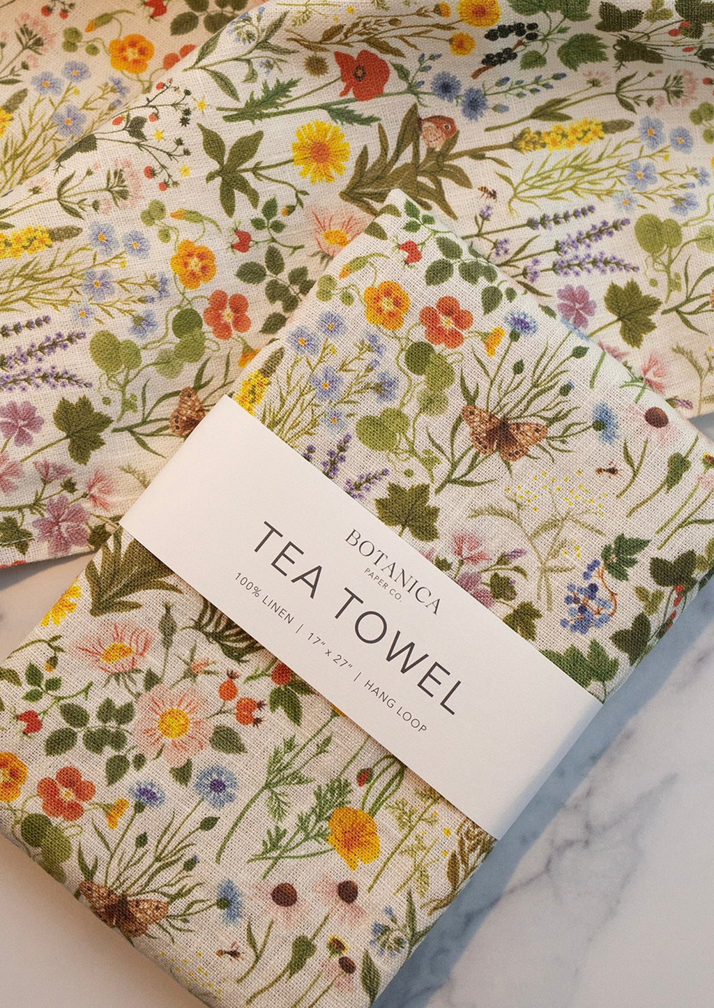 4: A linen tea towel with multicolor floral/botanical print.