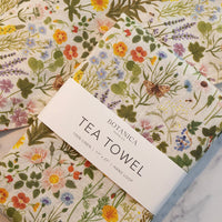4: A linen tea towel with multicolor floral/botanical print.