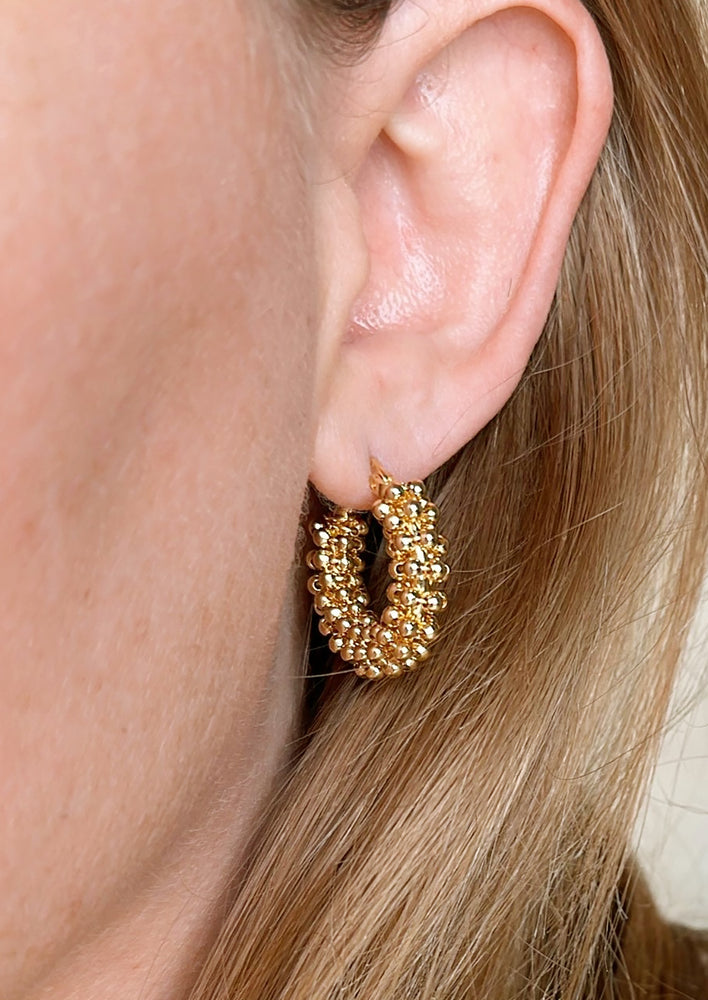 A pair of hoop earrings with all around cluster beading.