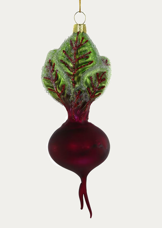 Decorative glass ornament shaped like a beet with green leaves on a white background