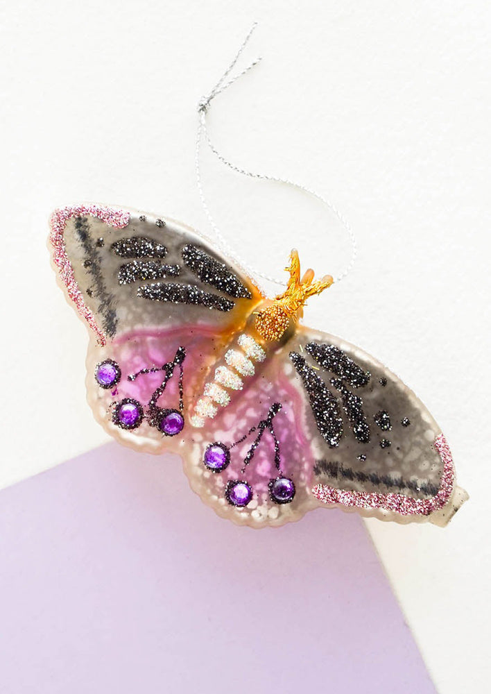 A purple and black bejeweled butterfly holiday ornament