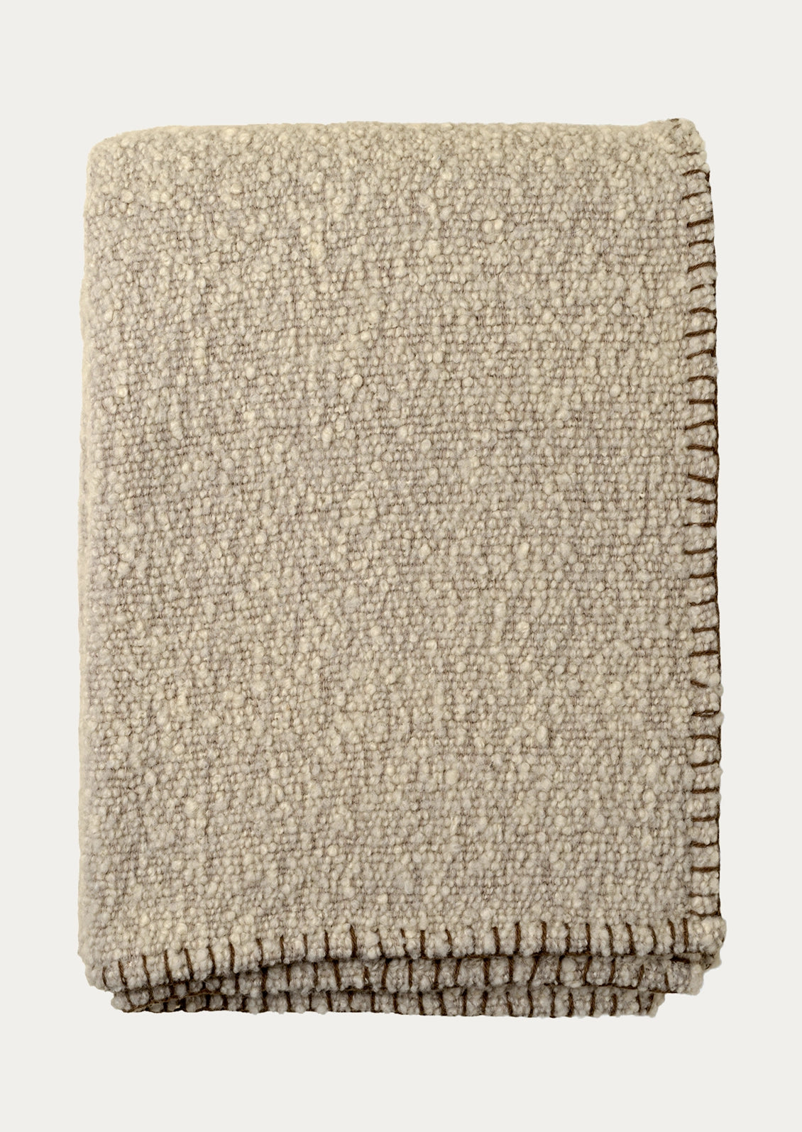 A folded taupe textured throw blanket with a whipstitched border in brown.