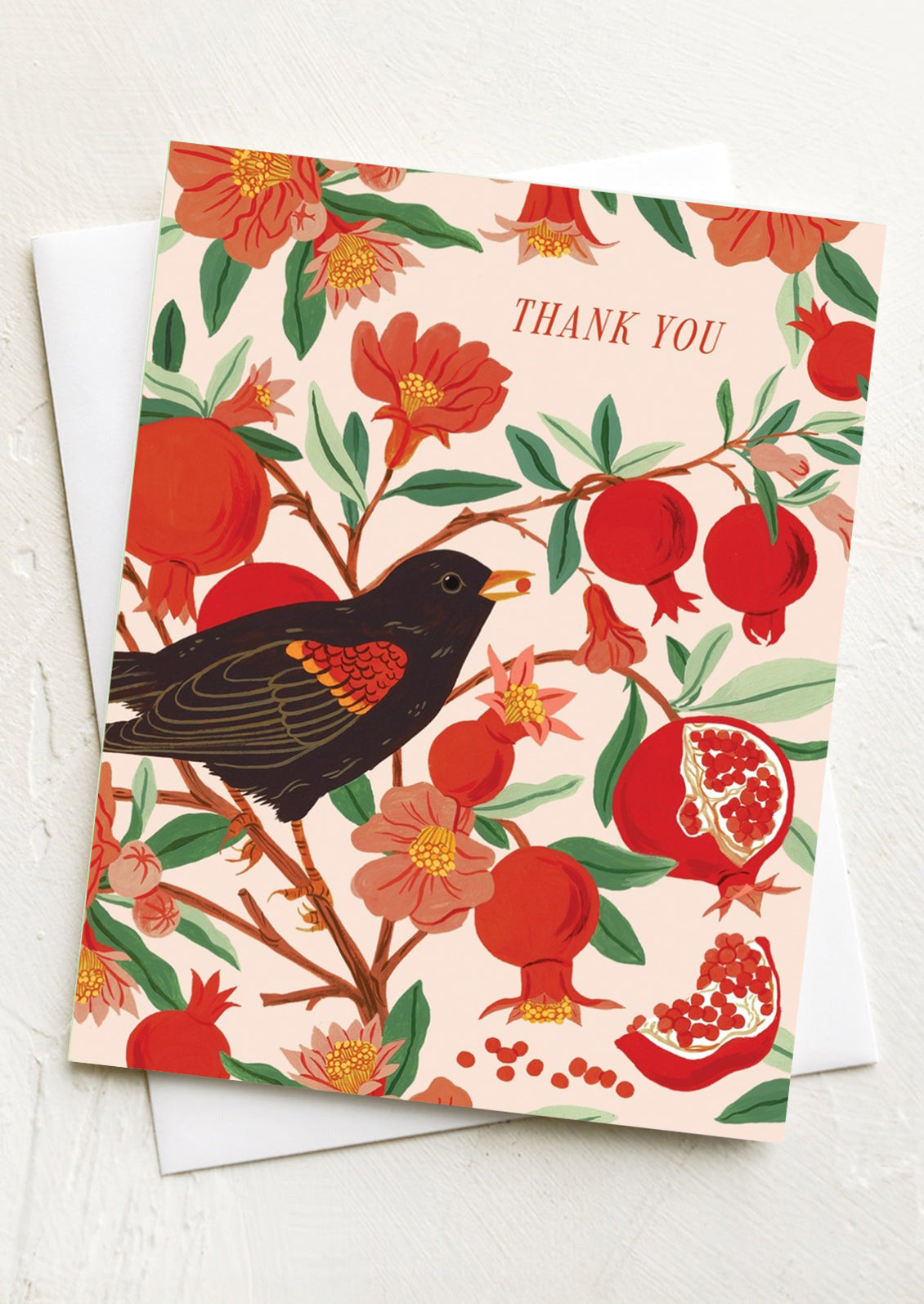 Greeting card with a bird and pomegranate design on a white background