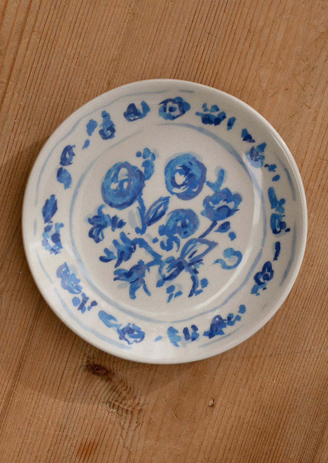 White plate with blue floral patterns on a wooden surface
