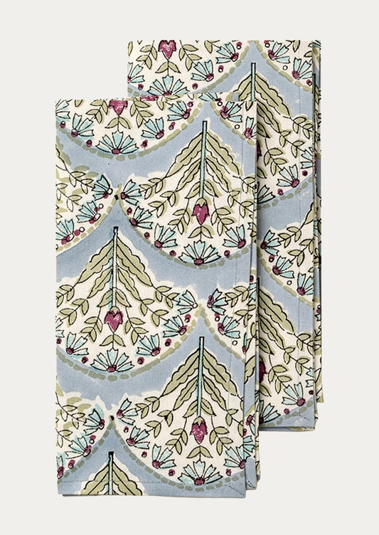 Set of two folded fabric napkins with a floral pattern on a light blue background