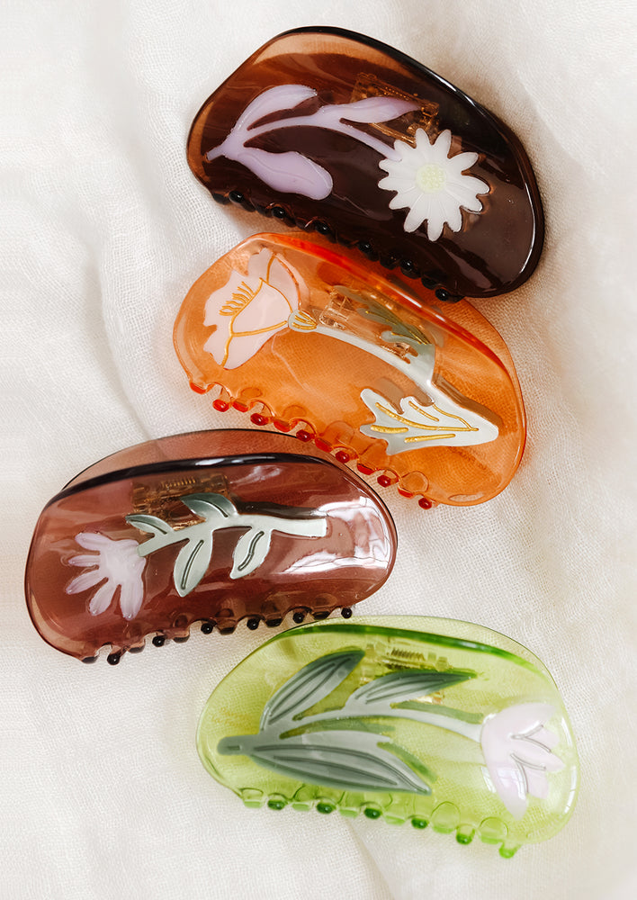 An assortment of hair claws in various colors with flower patterns.