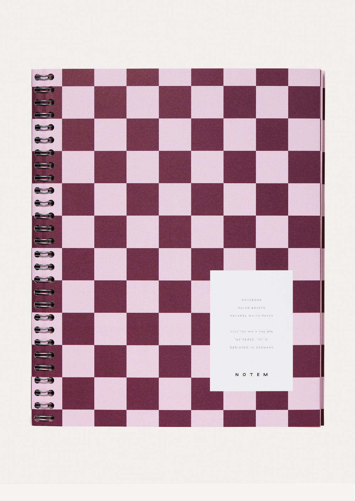 A spiral bound notebook with checker pattern cover in bordeaux.