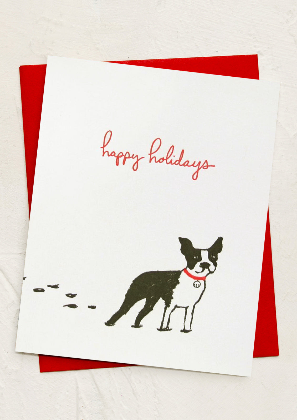 Greeting card with a dog illustration and 'happy holidays' text on a red envelope.