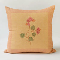 1: A block printed linen pillow in sand with pink bougainvillea print.