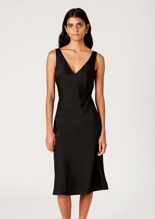 A woman wearing a satin v-neck sleeveless dress in black.