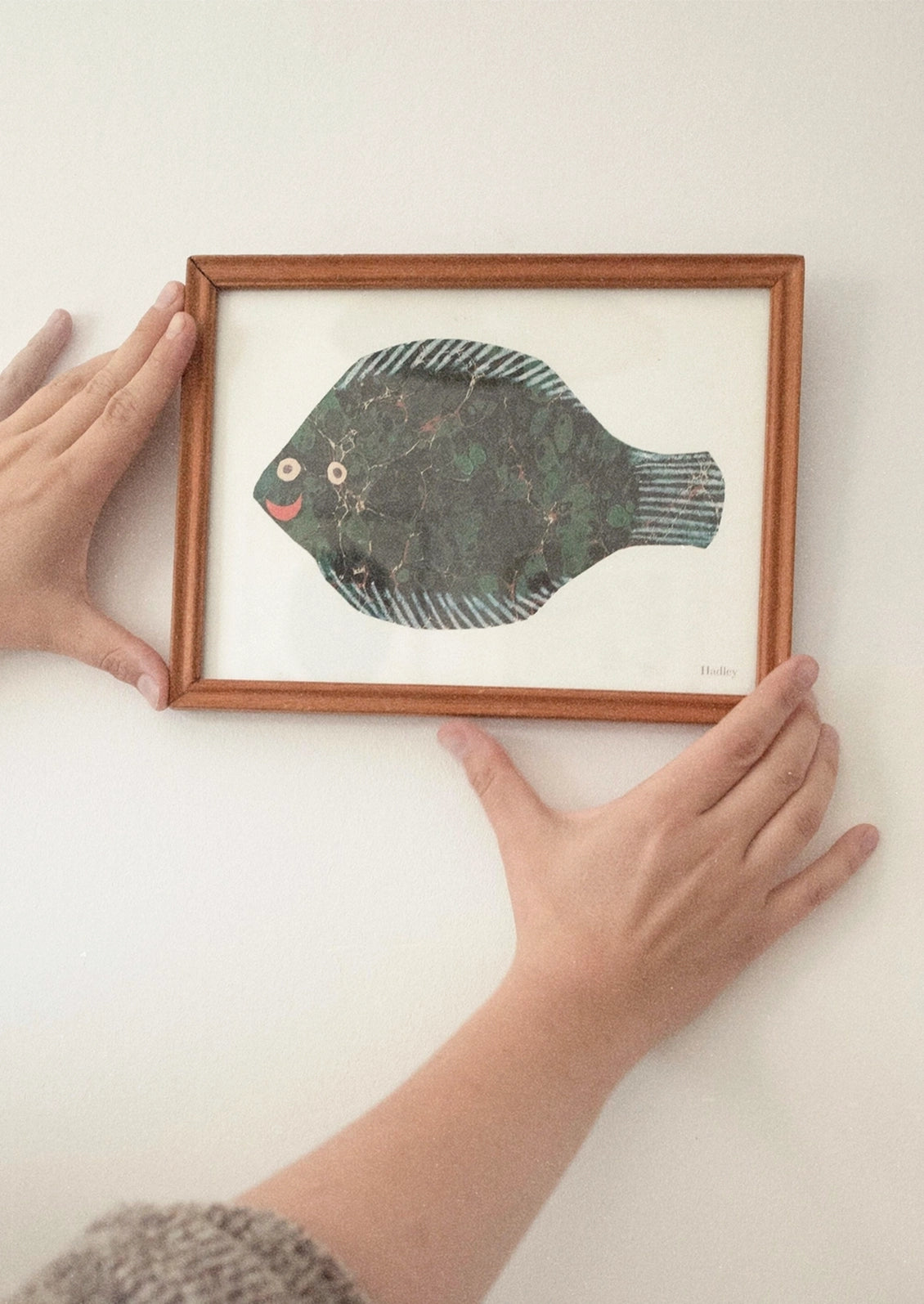 A small art print depicting a fish paper cutting.