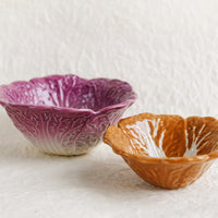 4: A pair of ceramic nesting bowls that look like orange and purple cabbage.