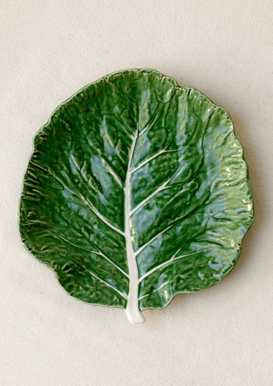 A ceramic serving "cabbageware" style salad plate that looks like green leaf of cabbage.