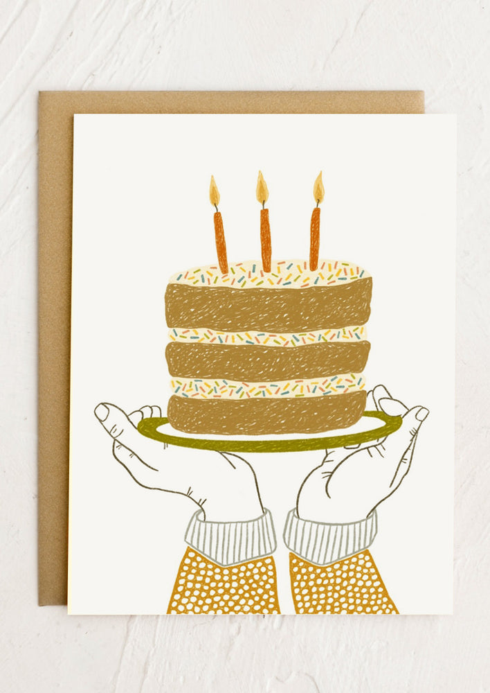 An illustrated birthday card depicting pair of hands holding birthday cake on a plate.