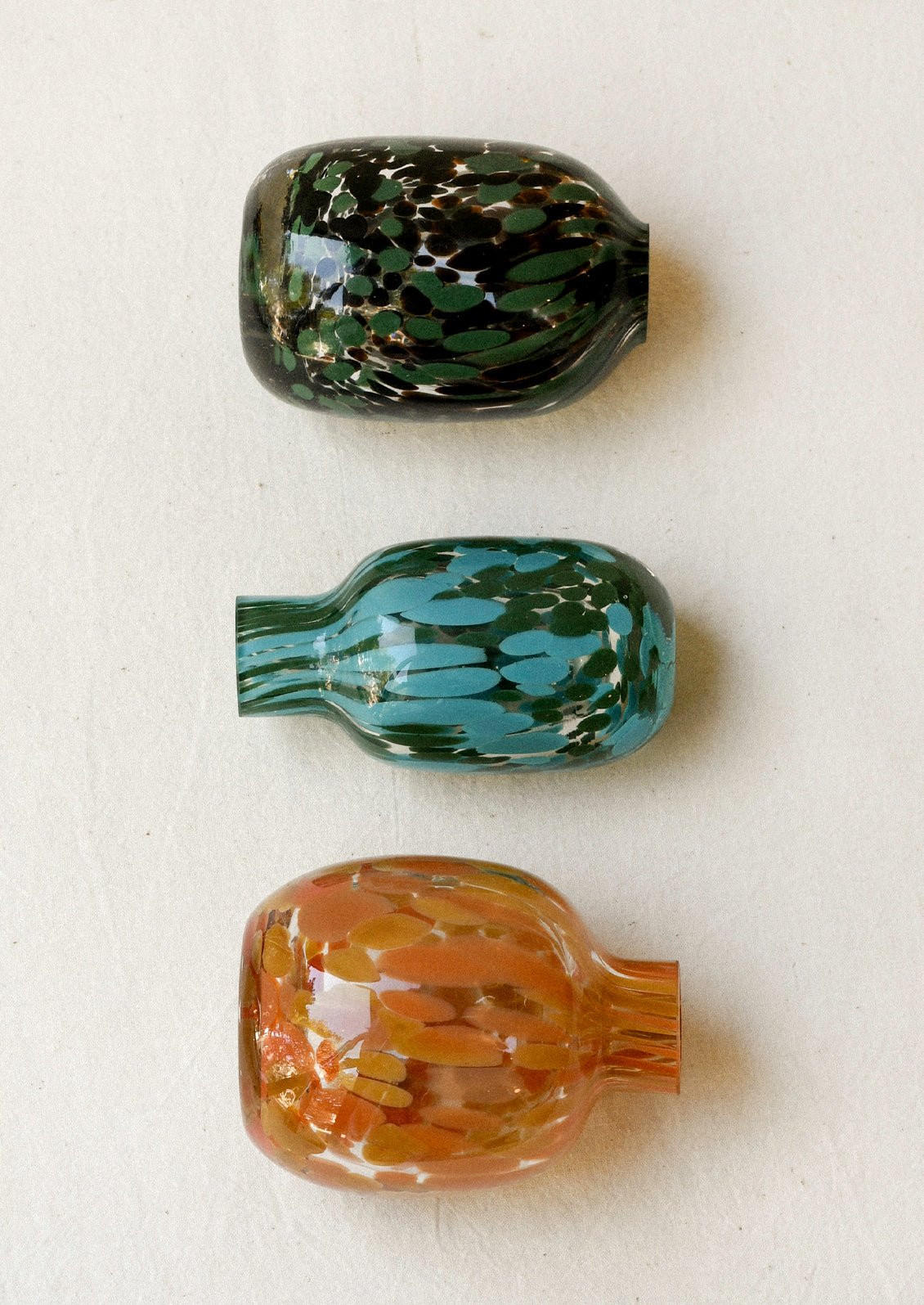 Small glass bud vases with a colorful painted design.