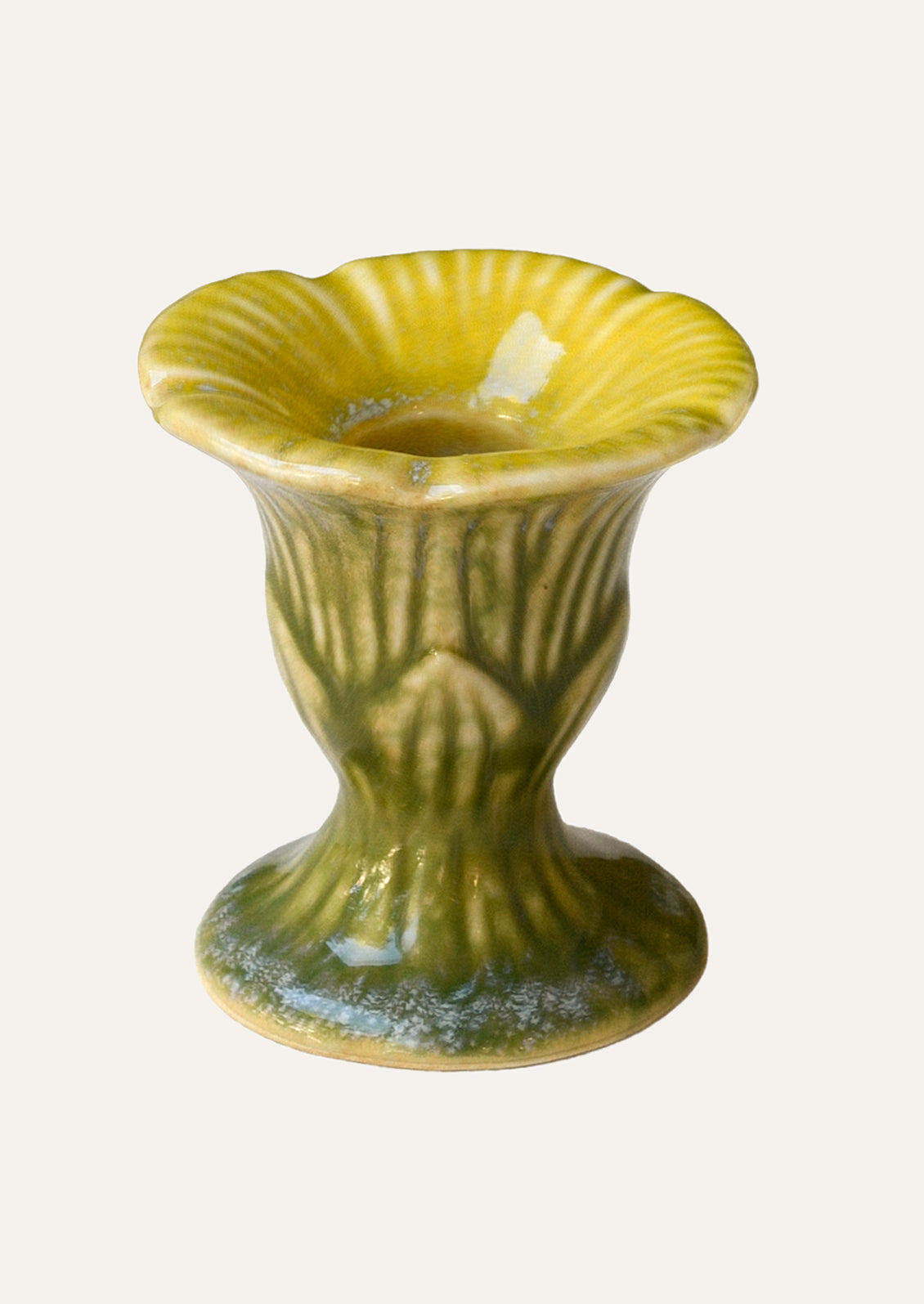 A yellow and green colored ceramic taper candle holder shaped like a flower.