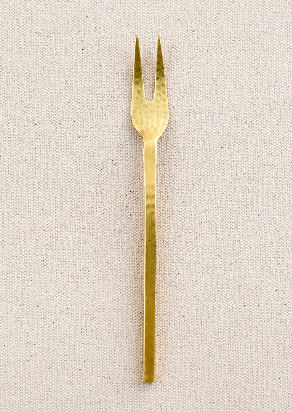 Fork: A small canape fork in hammered gold finish.