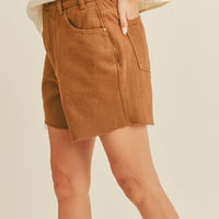 4: A woman in light brown denim shorts, seen from the side. 