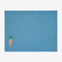 1: A blue cotton placemat with carrot embroidery at bottom left corner.