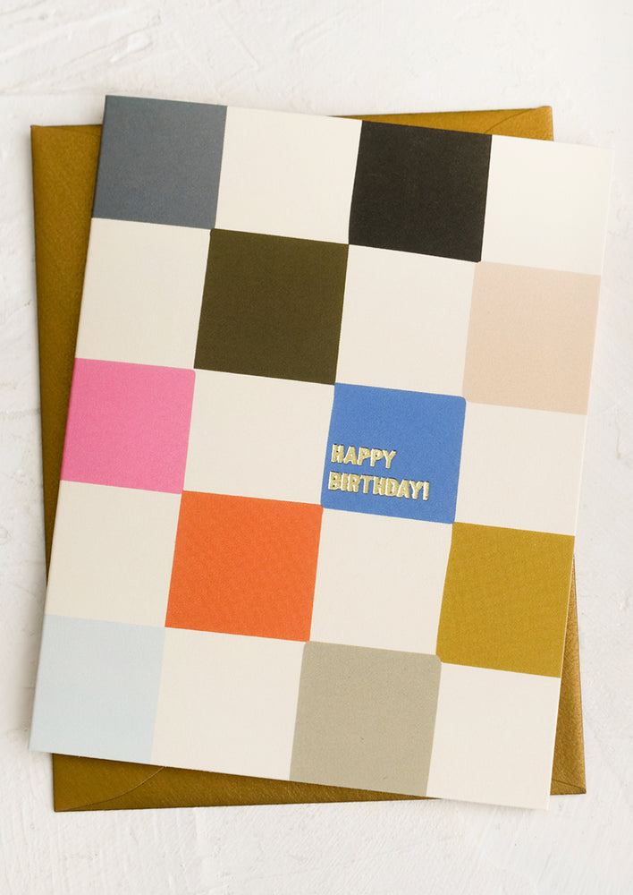 1: A multicolor checker print greeting card with gold text reading "Happy Birthday!".