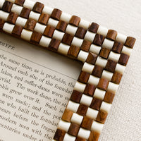 2: A picture frame with textural raised brown and white checker weave pattern.