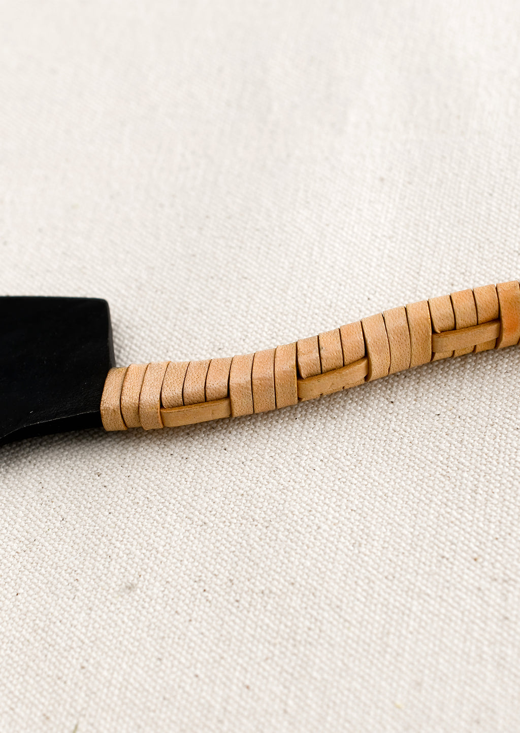 2: A black cast iron knife with natural leather wrapped handle.