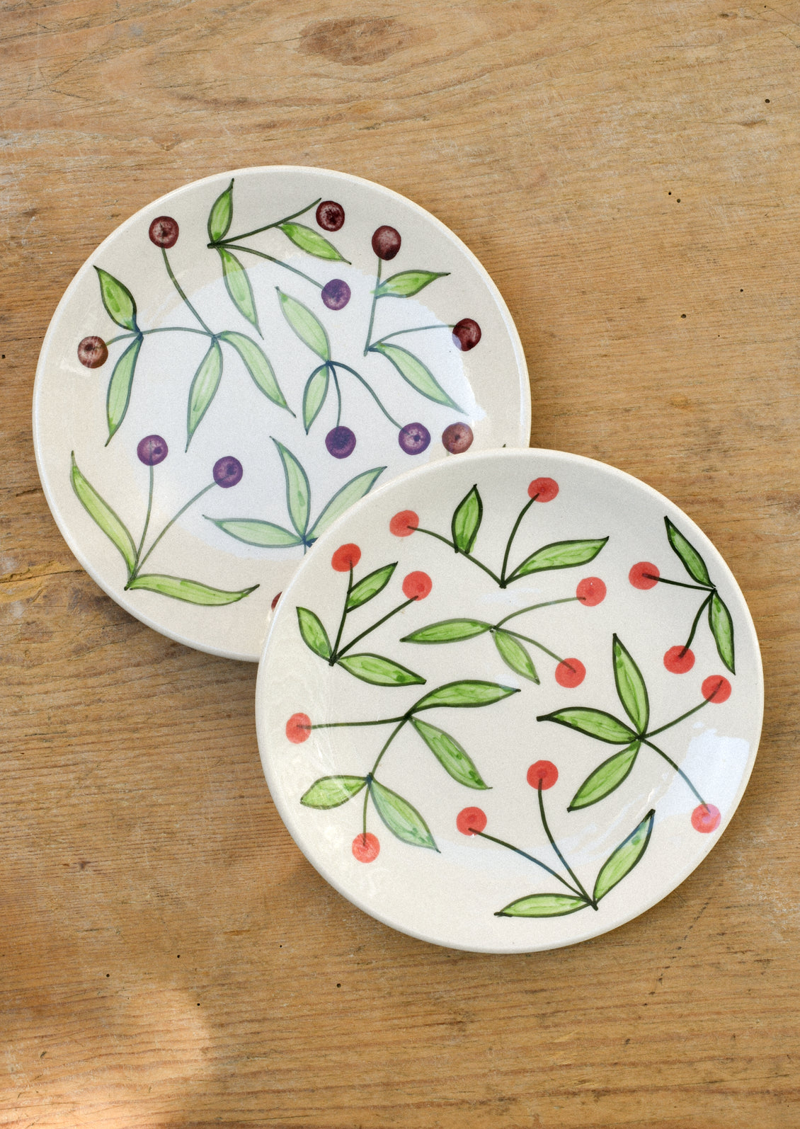 Ceramic plates with illustrated cherries.