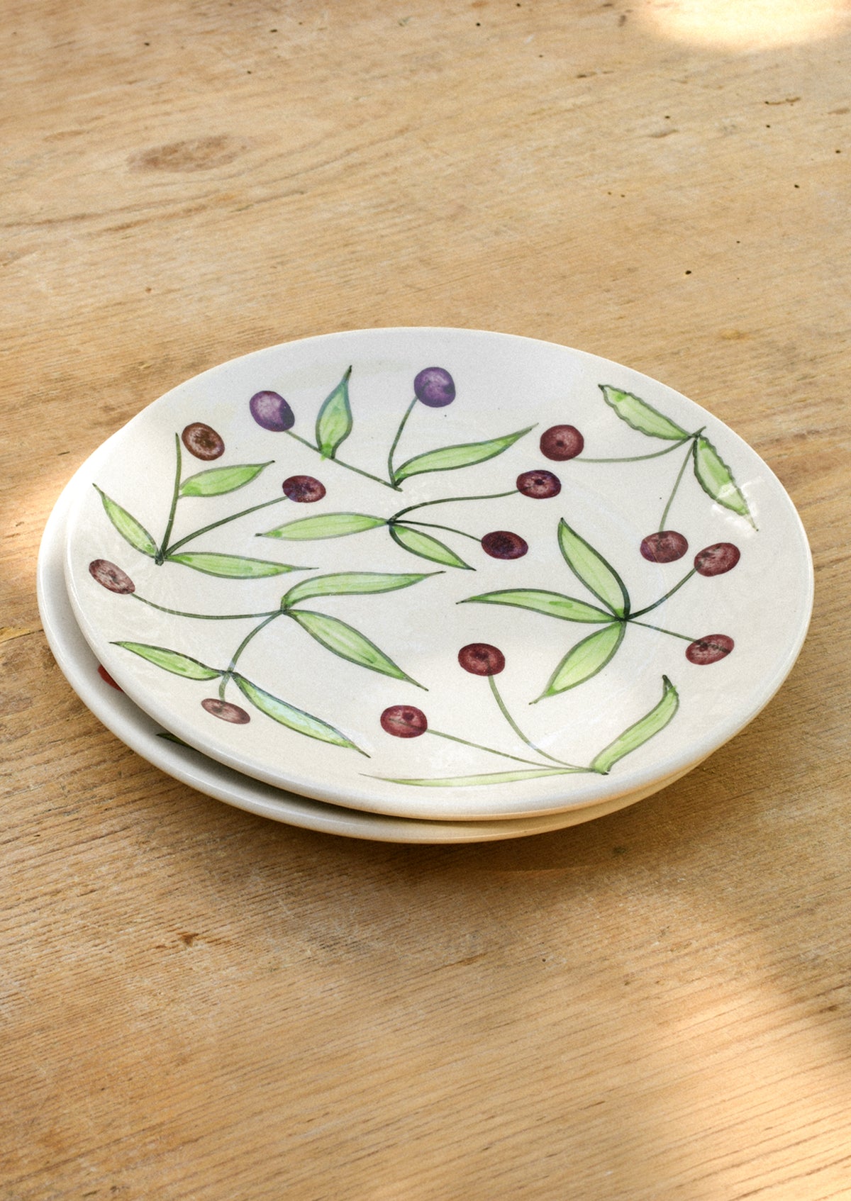 Ceramic plates with illustrated cherries.