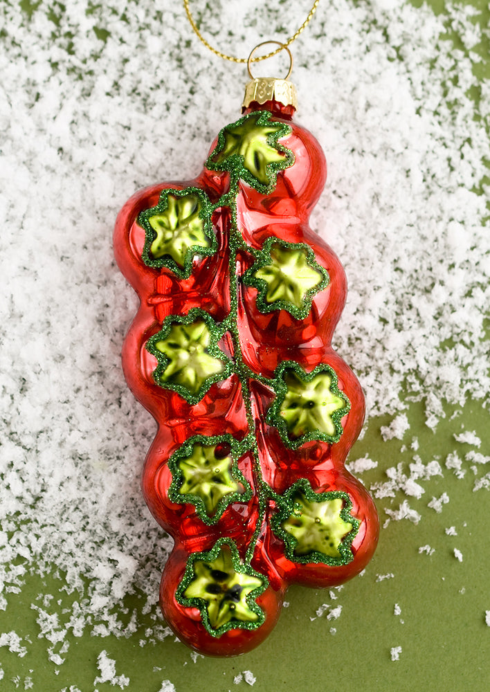 A glass ornament of cluster of red cherry tomatoes.