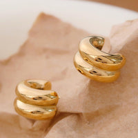 1: A pair of chunky rib textured hoop earrings in gold.