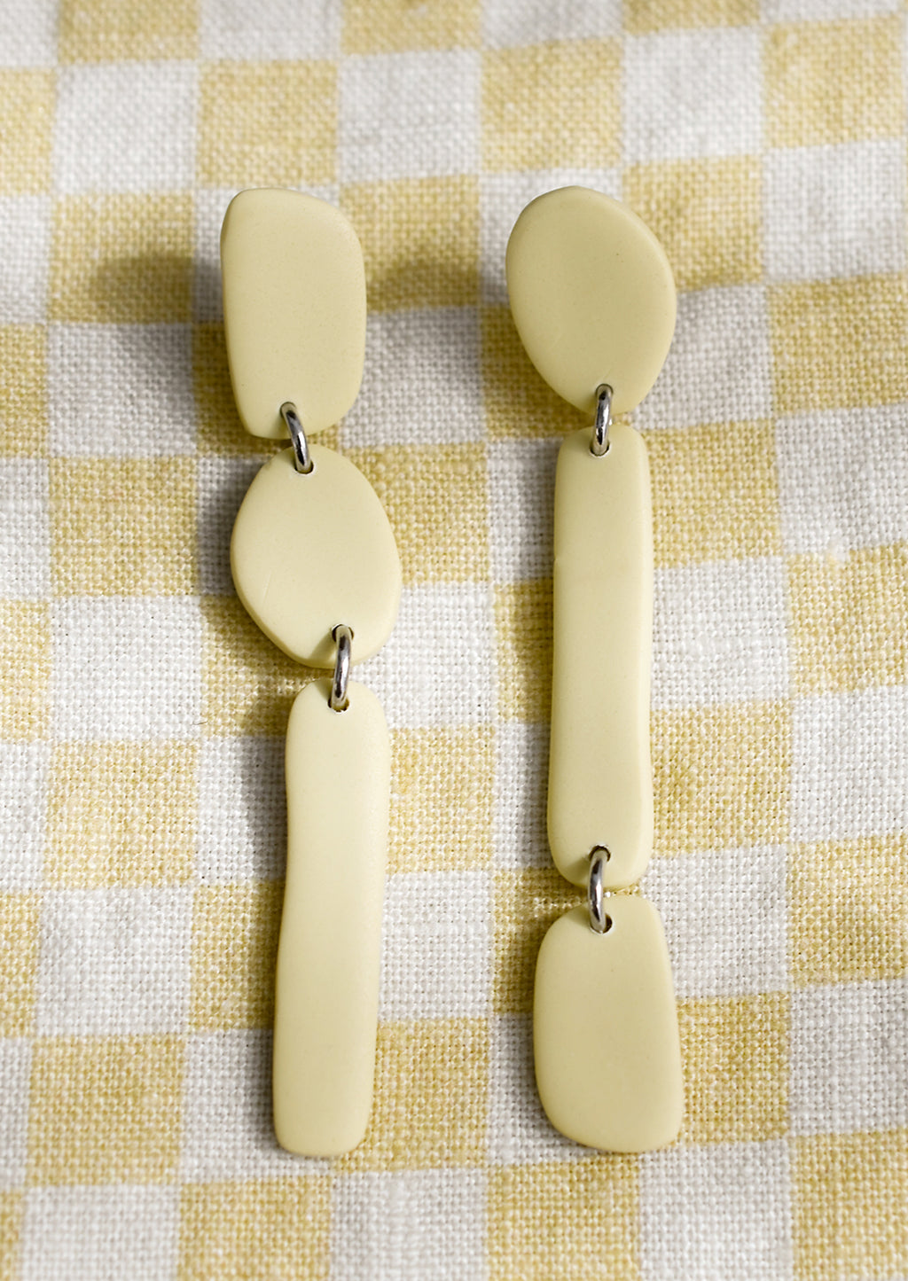 Butter Yellow: A pair of pale yellow clay earrings in post back drop silhouette.