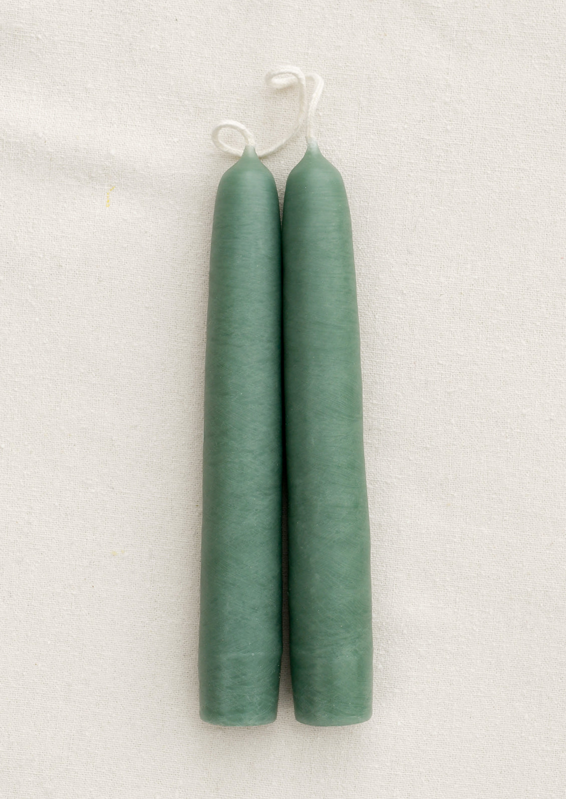 A pair of short taper candles in shade Clover.