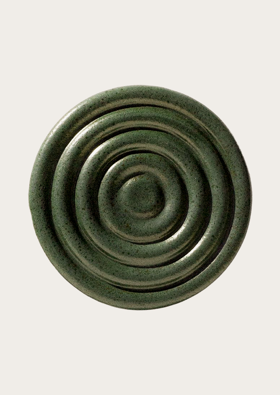 Handmade speckled ceramic coaster with a concentric design in forest green.