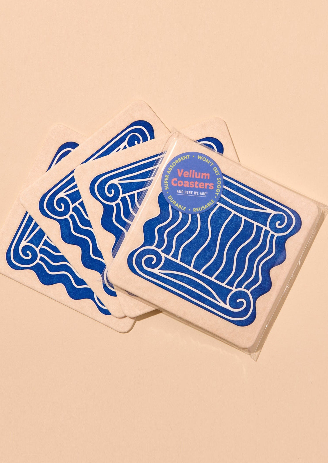 Set of coasters with blue column design on a beige background