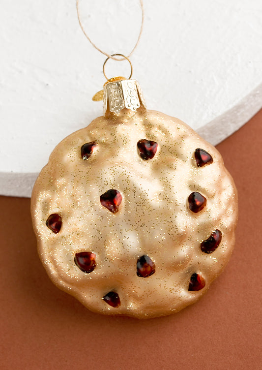 A glass holiday ornament of a chocolate chip cookie.