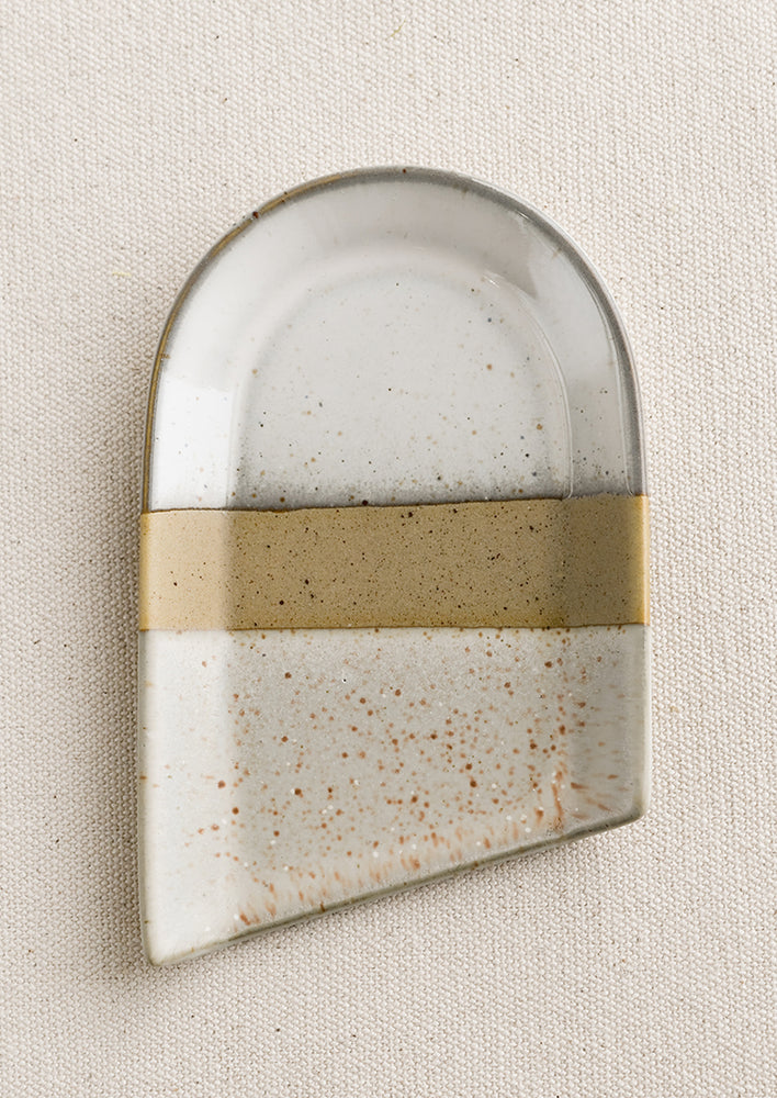 A spoon rest in asymmetrical shape with diagonal edge and natural glaze.