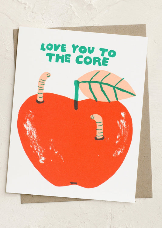 Card with an illustration of an apple, worms, and a leaf with text 'Love you to the core' on a light background.