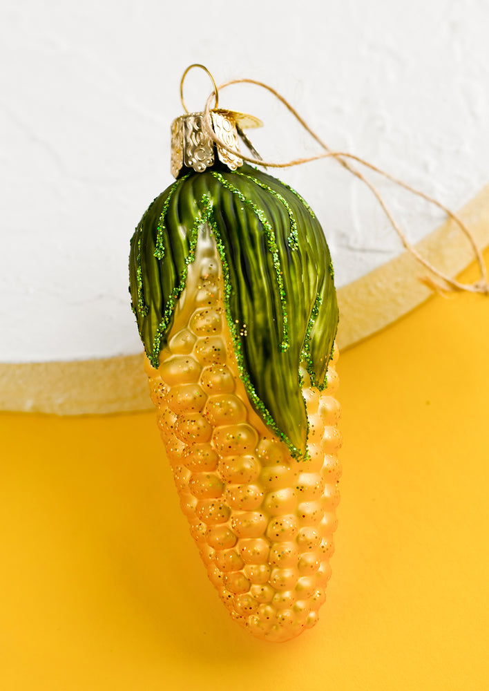 1: A glass ornament of ear of yellow corn.