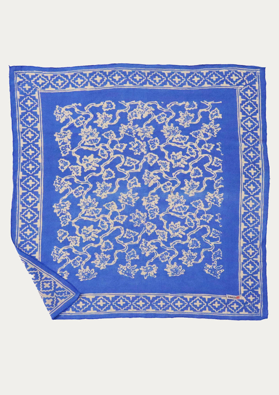 A square cotton bandana in cornflower blue with white floral print.