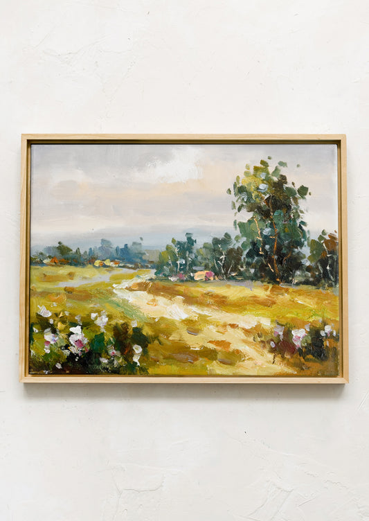 A framed original oil painting of a colorful meadow in the countryside.