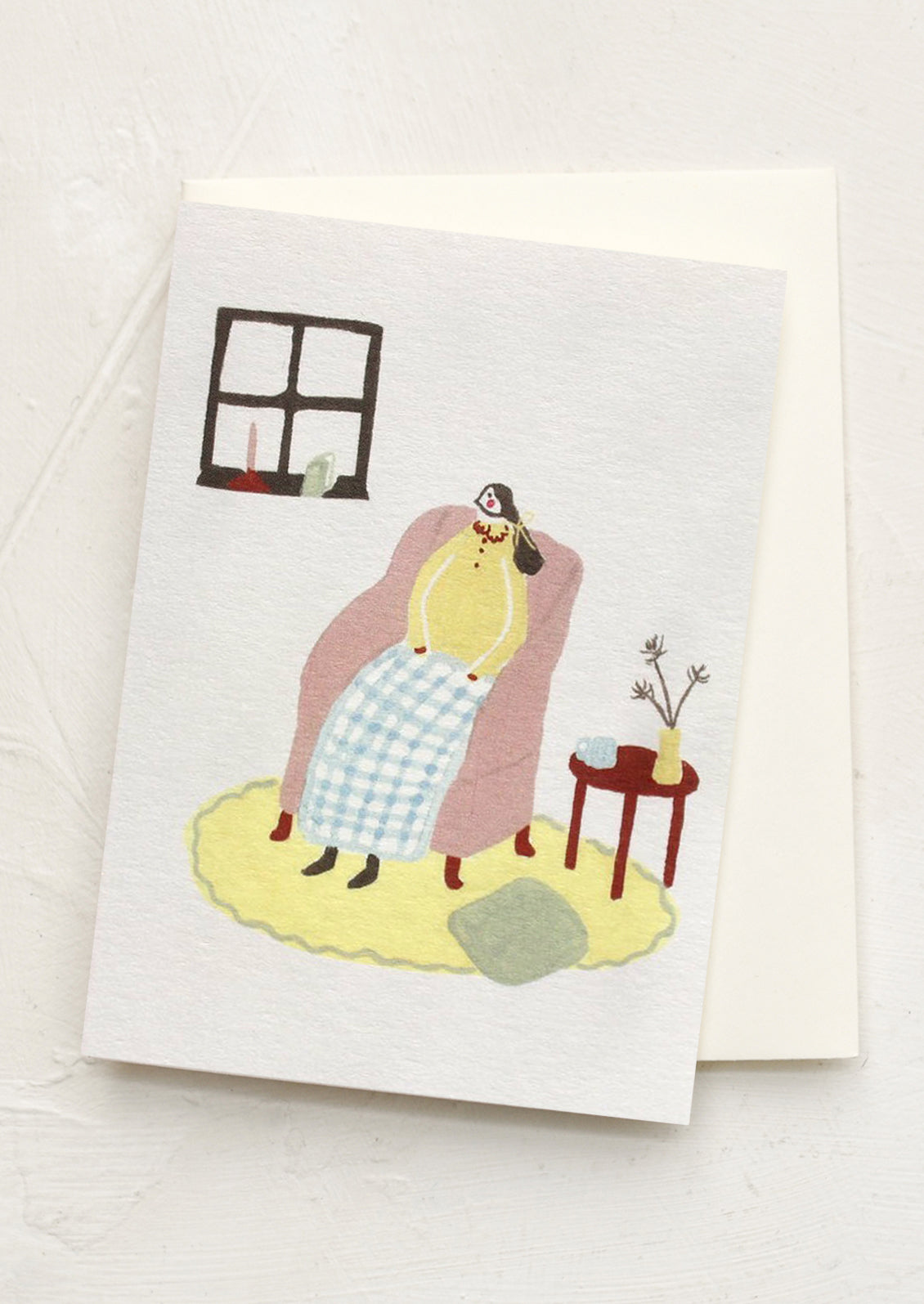 Greeting card with a cartoon character sitting on a couch in a room.
