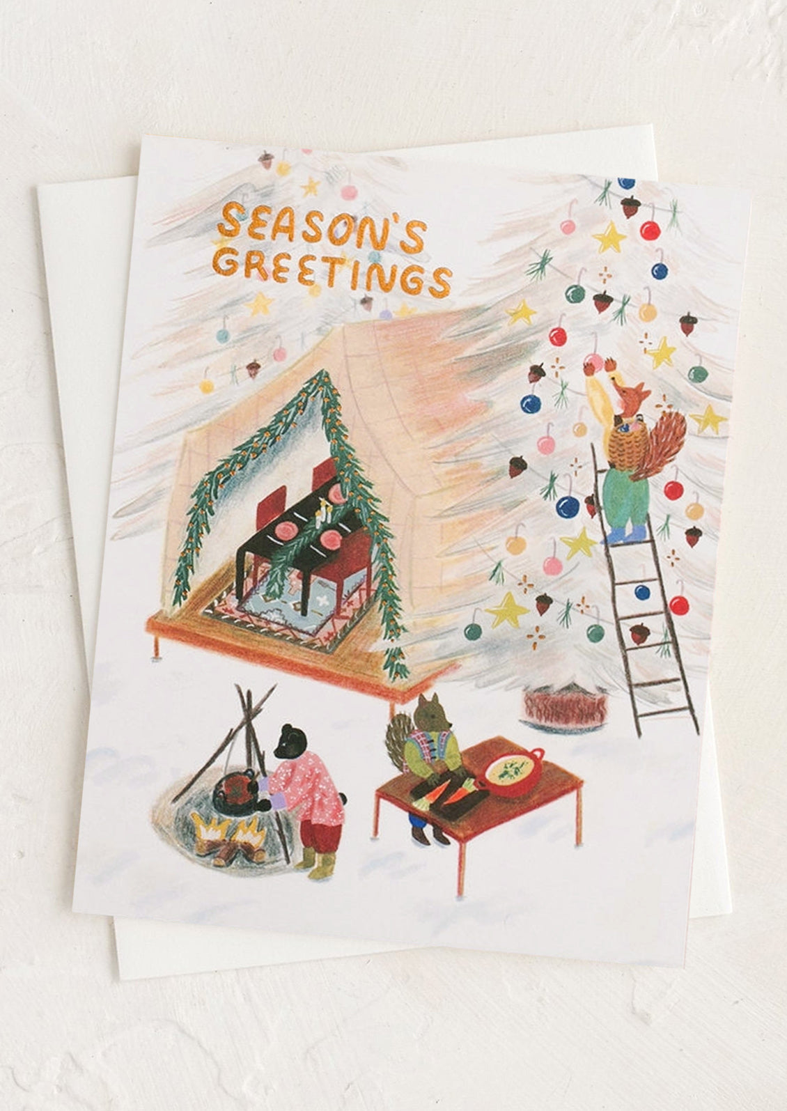 A greeting card with illustrations of animals doing festive winter activities, text reads "Season's Greetings".