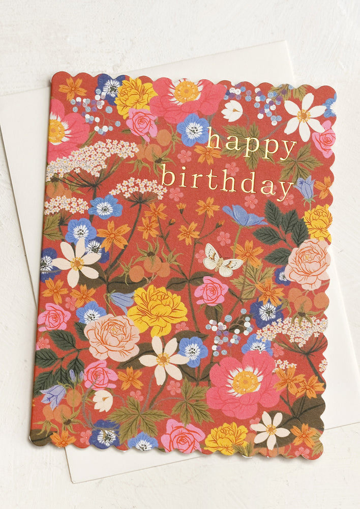 A red floral print card with scalloped edges reads "Happy Birthday".