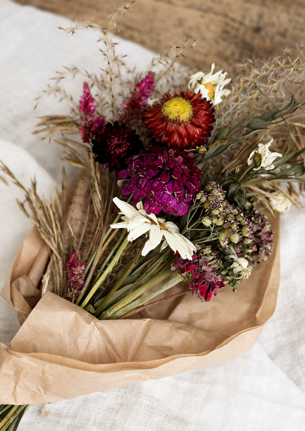 1: A dried flower bouquet in dark red and pink tones.